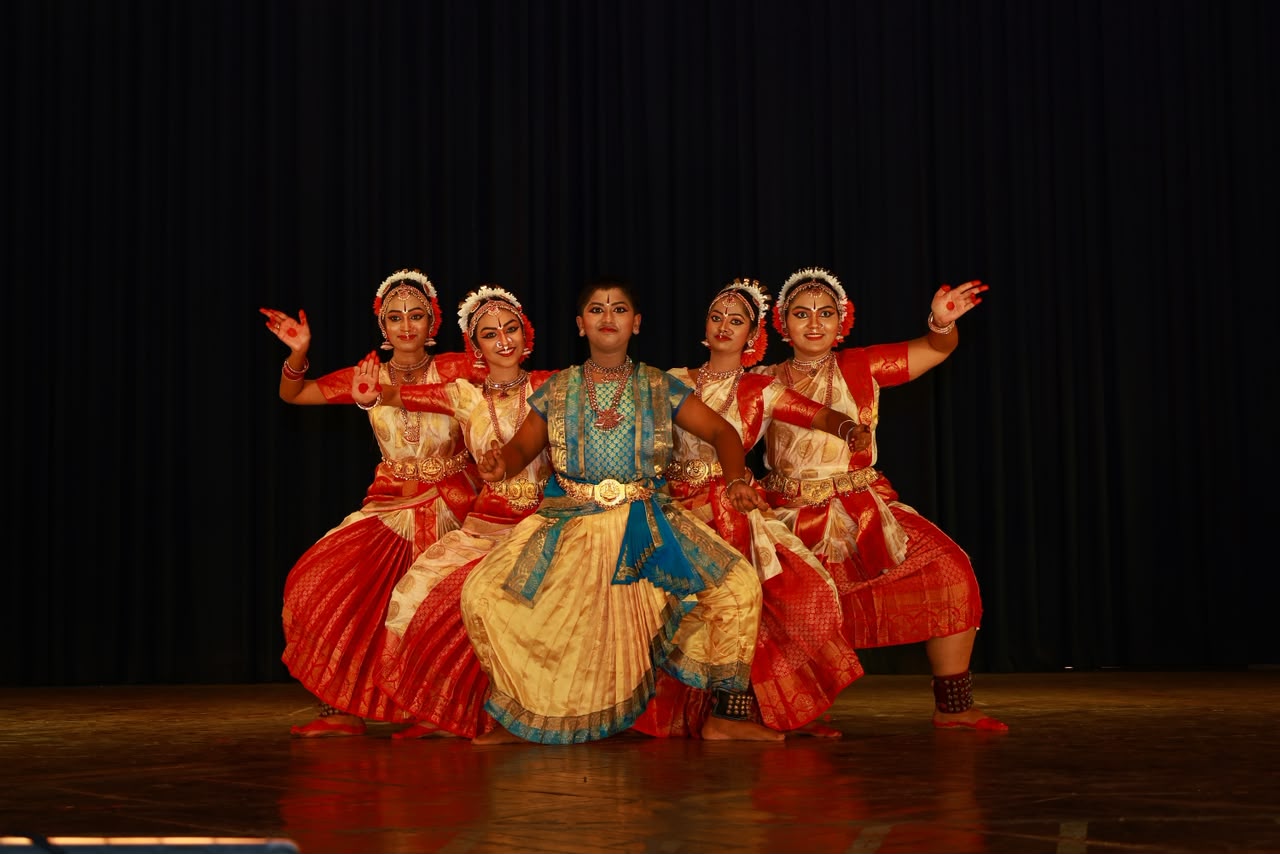 Five young dancers in matching costumes, mid-pose