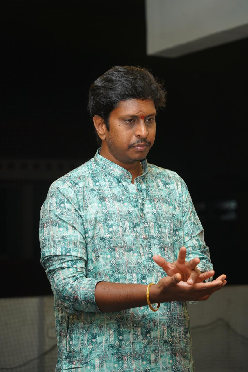 Vid. Sri. Anand Srihari training his mridangam disciples, mid-gesture